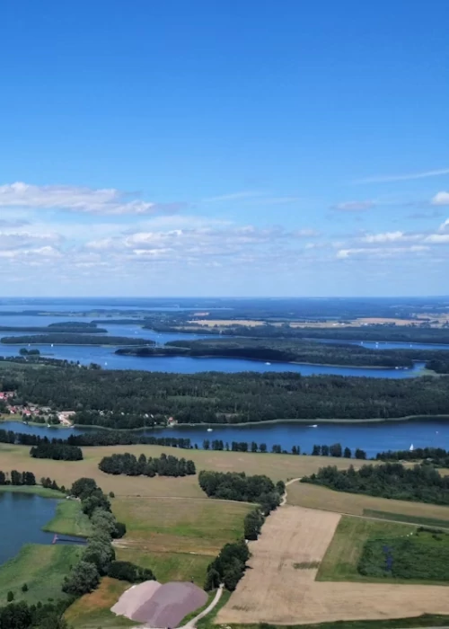 Widok z lotu ptaka na jeziora i lasy na Mazurach – luksusowe domki do wynajęcia